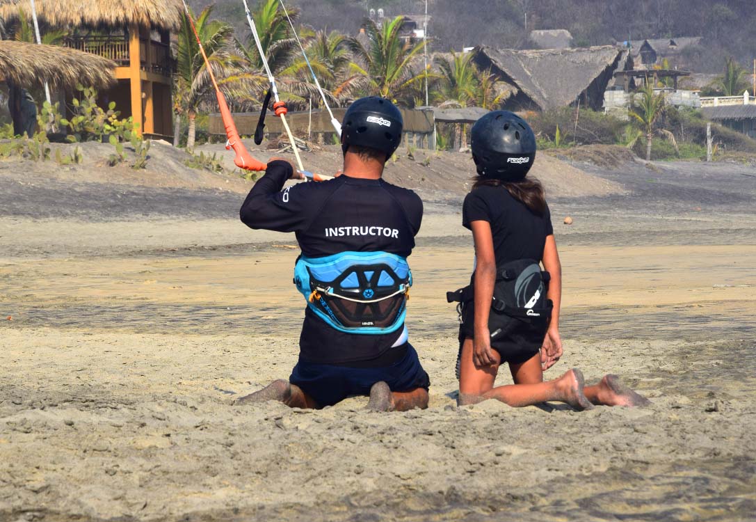 instructor with child learning kitesurf by oaxakite